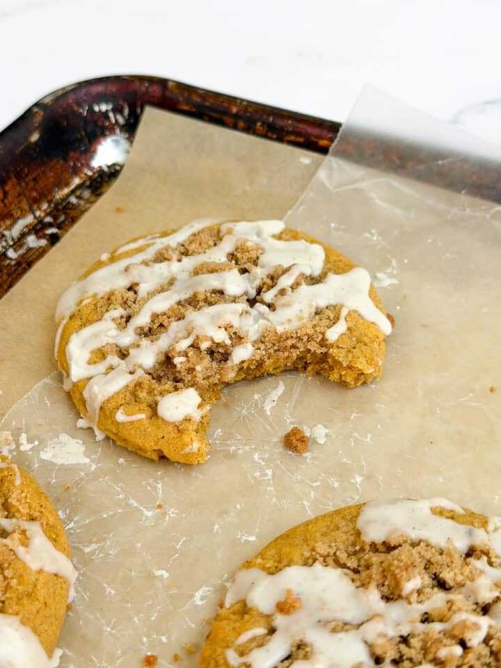 a pumpkin coffee cake cookie with a bite missing.